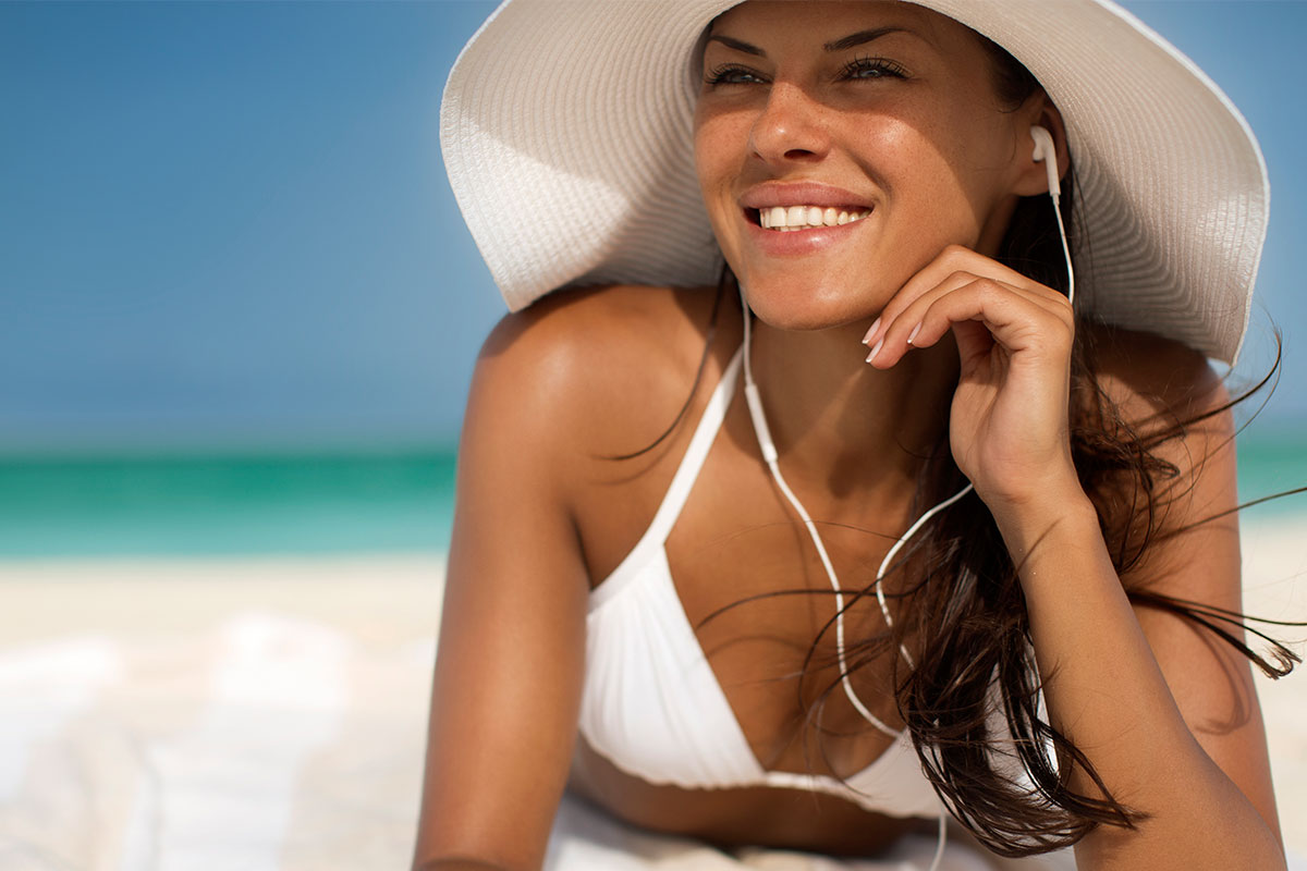 Smiling woman on the beach after acne scar removal in Los Angeles